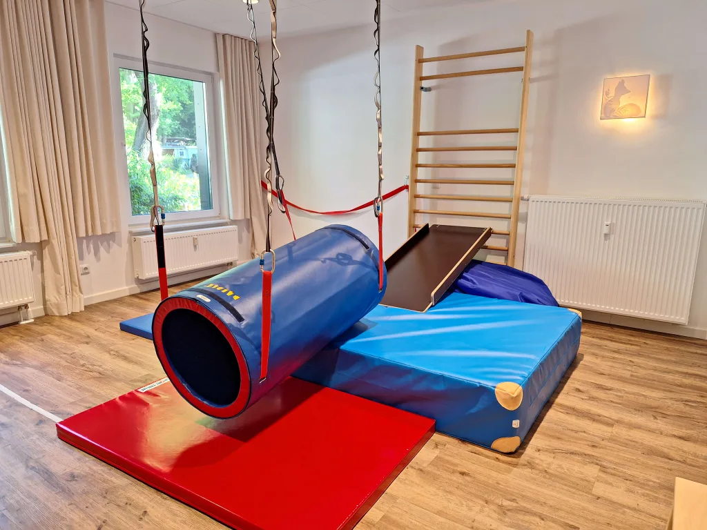 Fotoaufnahme eines Spielzimmers im Kinderkompass mit Kletterwand, Tunnel und Matten